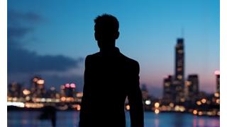 A confident, elegantly dressed person looking out over a city, symbolizing empowerment and sophistication.