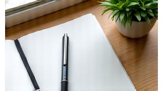 A serene desk setting with a notebook, pen, and a plant, creating an atmosphere of concentration and clarity.