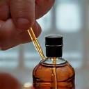 Close-up of Kai Akira meticulously blending essential oils in a minimalist lab setting.